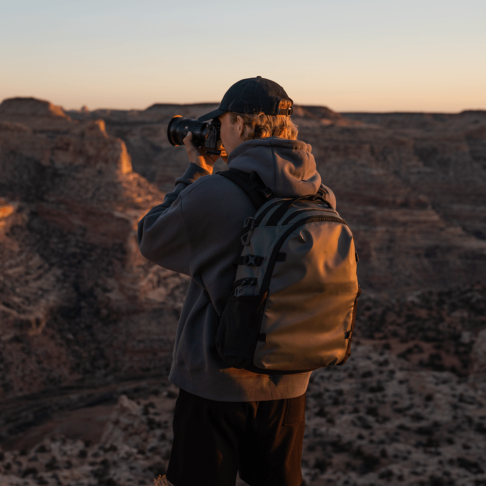 Green Stratus Photo 18L Backpack on man using a camera