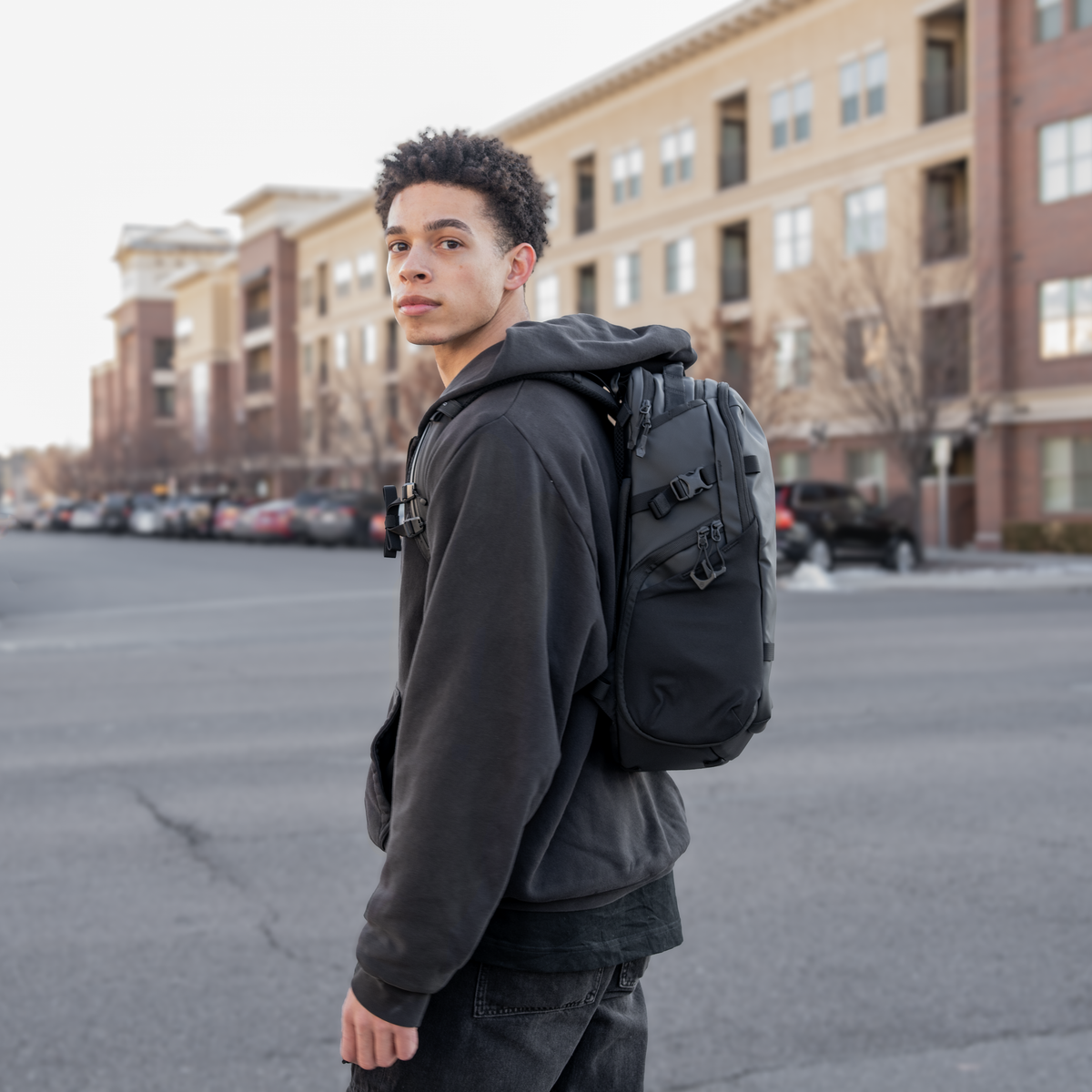 Man wearing Black Stratus Photo 18L Backpack Side